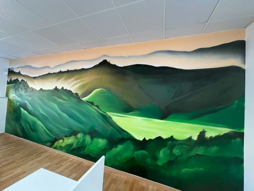 Paisaje mural en call center de Euromaster con montañas verdes