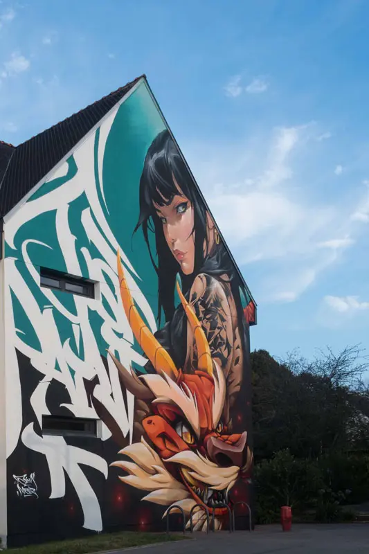 Retrato moderno de Mulán y dragón oriental en mural artístico en Queven