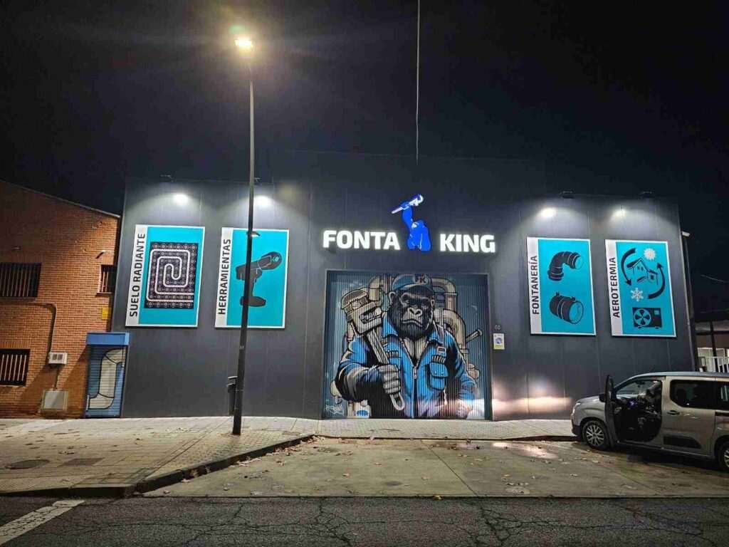 Fachada de negocio Fontaking terminada de noche con mural industrial y rotulación corporativa