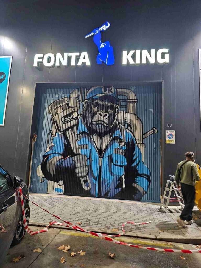 Graffiti corporativo en fachada de Fontaking con gorila uniformado y branding iluminado de noche