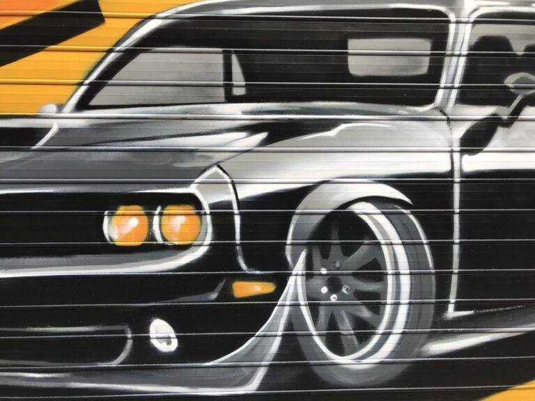 Graffiti de coche deportivo en sede de Autoescuelas Gala en Gran Vía