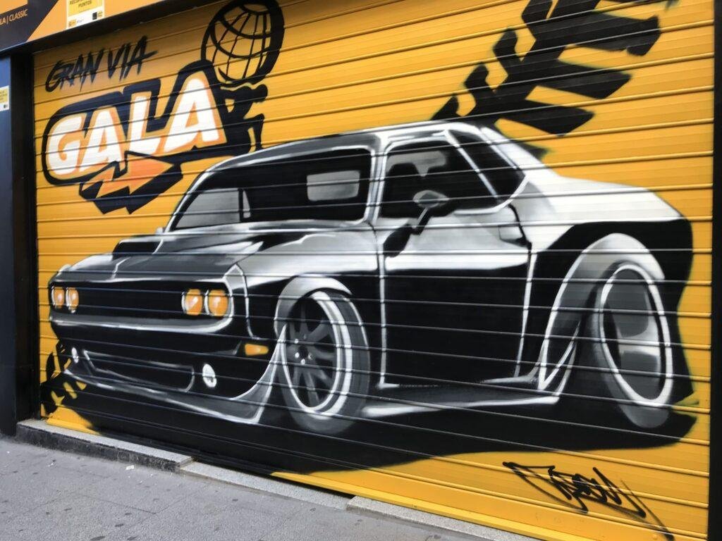 Graffiti de coche deportivo en sede de Autoescuelas Gala en Gran Vía