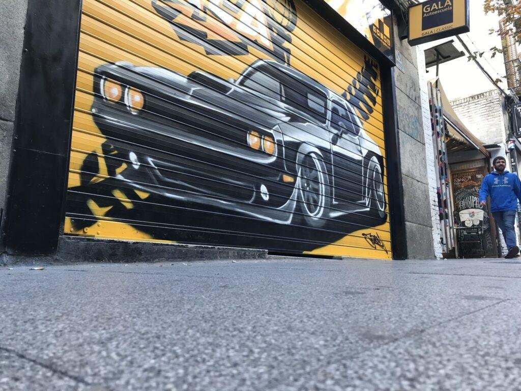 Graffiti de coche deportivo en sede de Autoescuelas Gala en Gran Vía