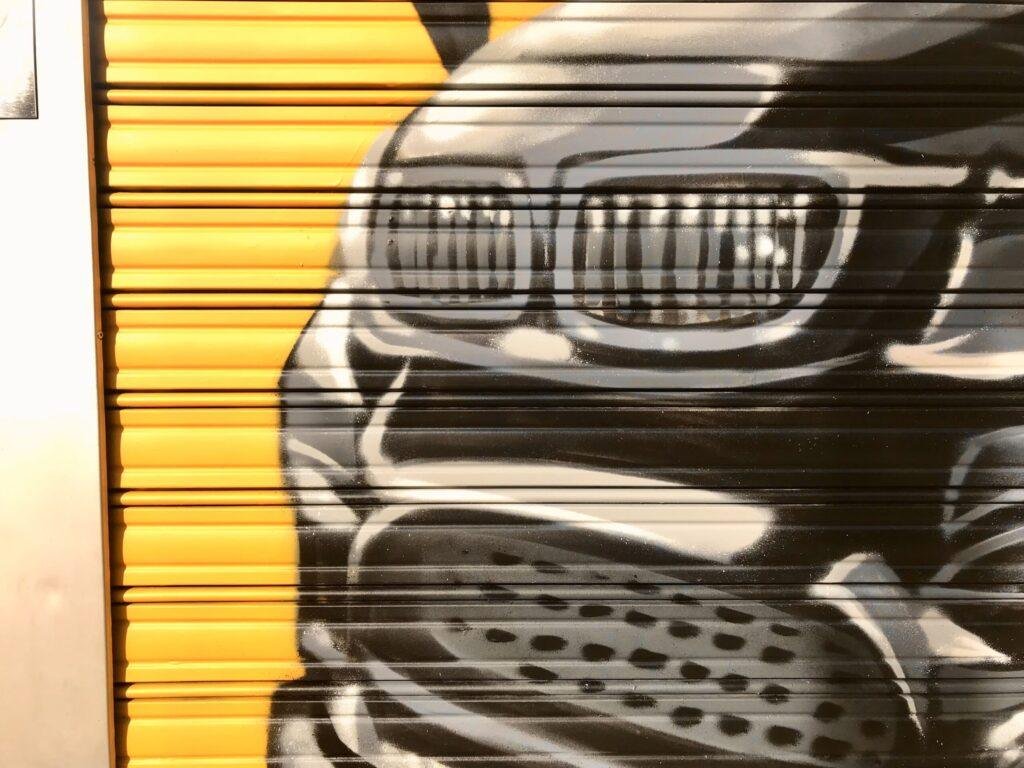 Graffiti BMW negro en persiana de Gala en Paseo de Extremadura