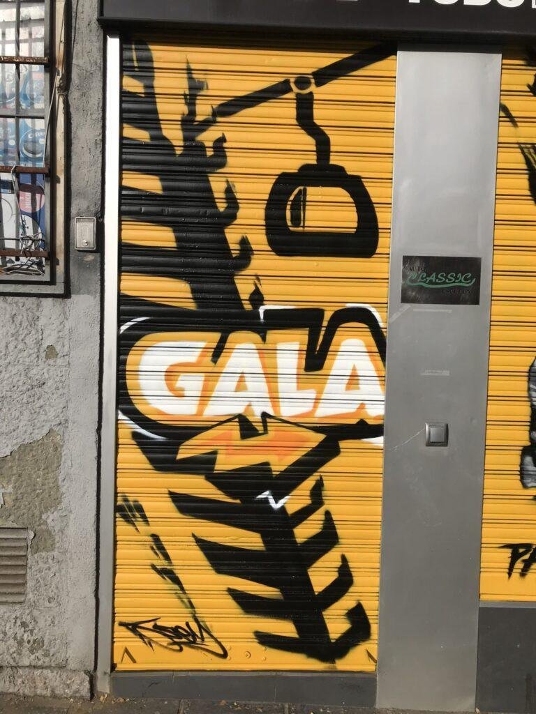 Graffiti BMW negro en persiana de Gala en Paseo de Extremadura