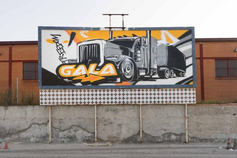 Graffiti con tráiler y texto en vallas publicitarias de Autoescuelas Gala