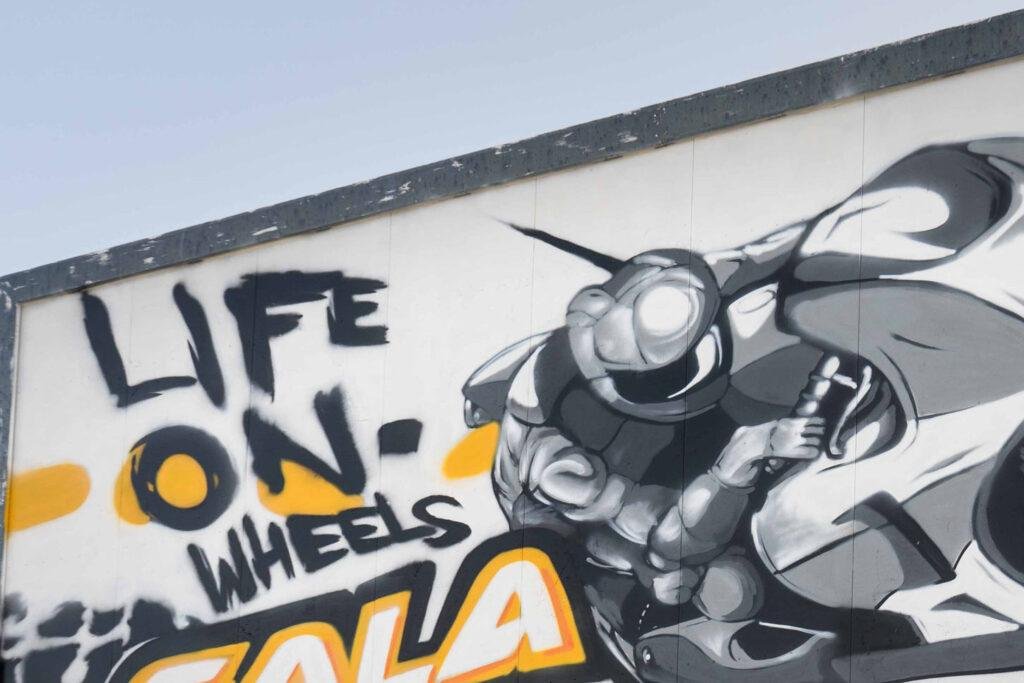Graffiti con tráiler y texto en vallas publicitarias de Autoescuelas Gala