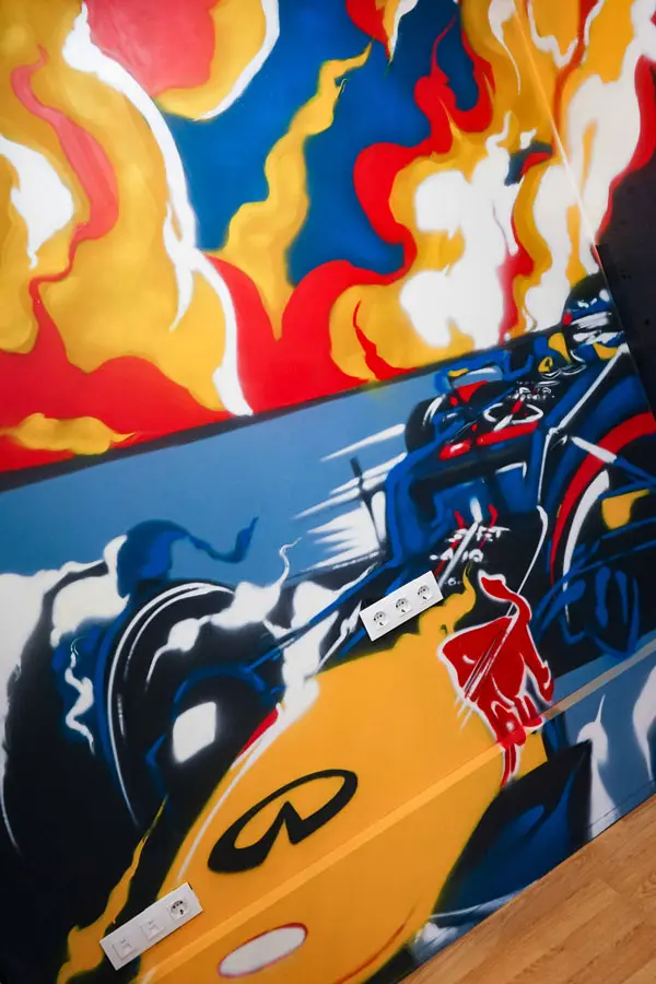 Graffiti de Red Bull con F1 y llamas en espacio interior, mural con energía y acción