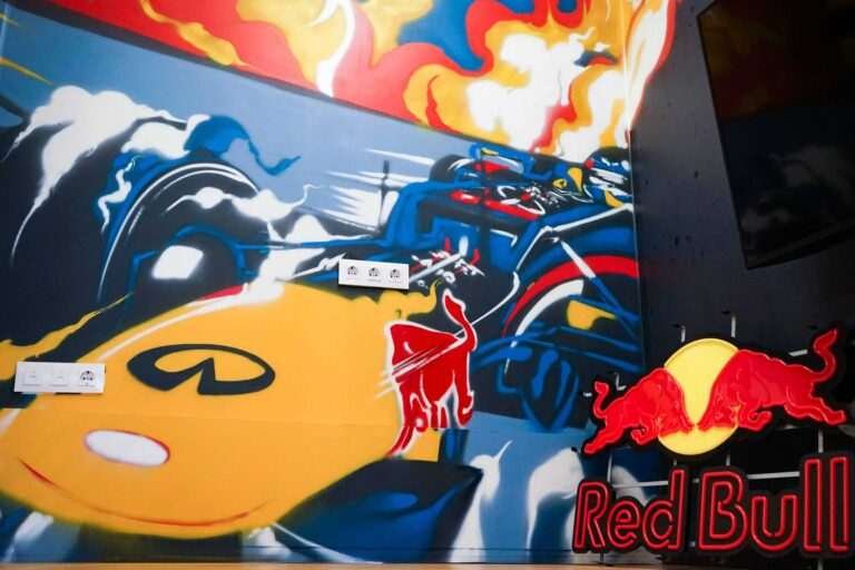 Graffiti de Red Bull con F1 y llamas en espacio interior, mural con energía y acción