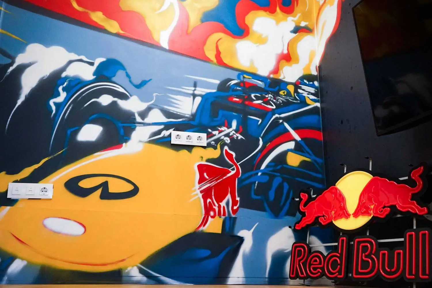 Graffiti de Red Bull con F1 y llamas en espacio interior, mural con energía y acción