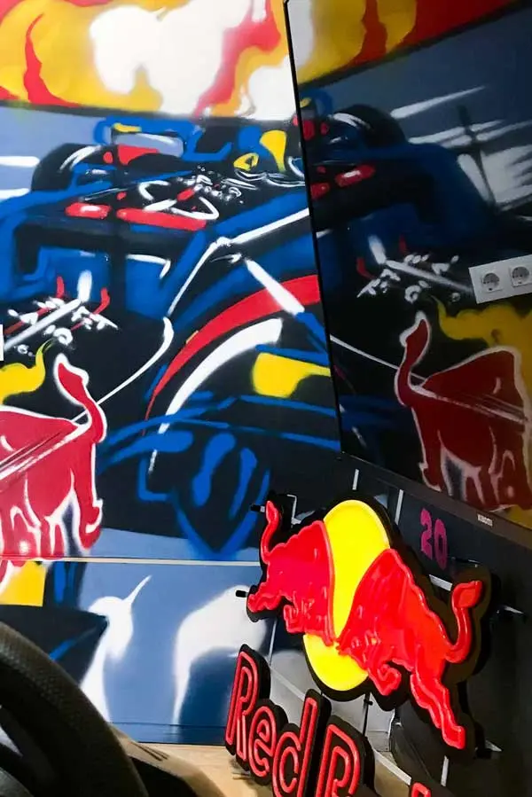 Graffiti de Red Bull con F1 y llamas en espacio interior, mural con energía y acción