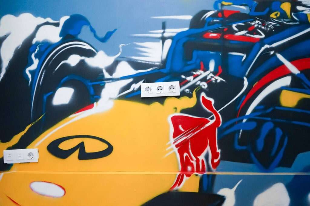 Graffiti de Red Bull con F1 y llamas en espacio interior, mural con energía y acción