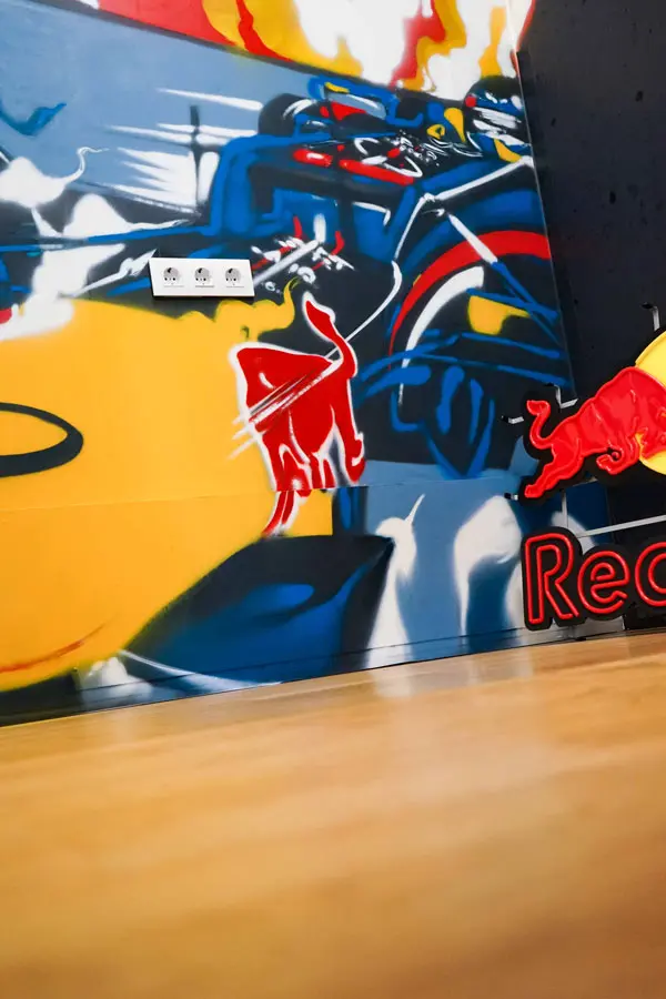Graffiti de Red Bull con F1 y llamas en espacio interior, mural con energía y acción