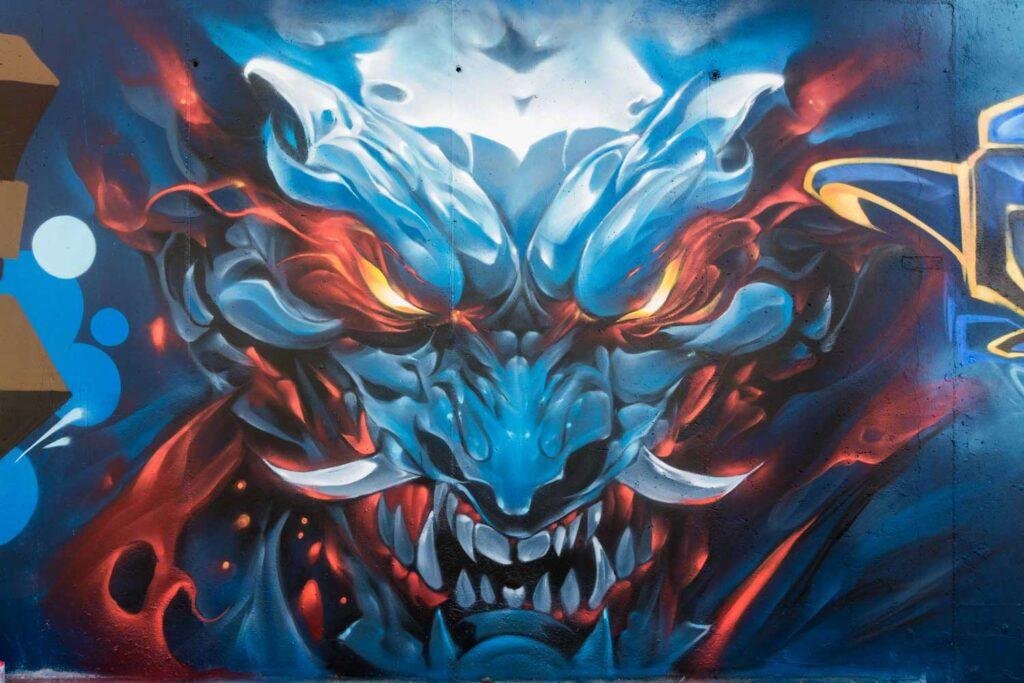 Graffiti de demonio japonés azul con ojos encendidos en Madrid