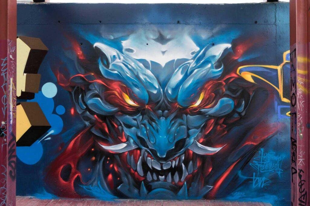 Graffiti de demonio japonés azul con ojos encendidos en Madrid