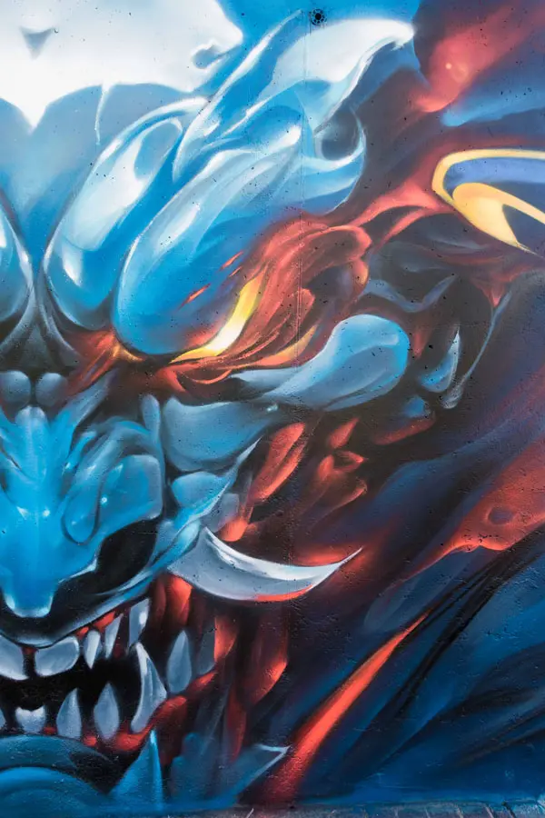 Graffiti de demonio japonés azul con ojos encendidos en Madrid