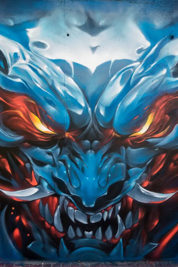 Graffiti de demonio japonés azul con ojos encendidos en Madrid
