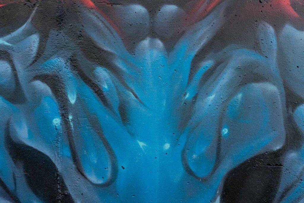 Graffiti de demonio japonés azul con ojos encendidos en Madrid