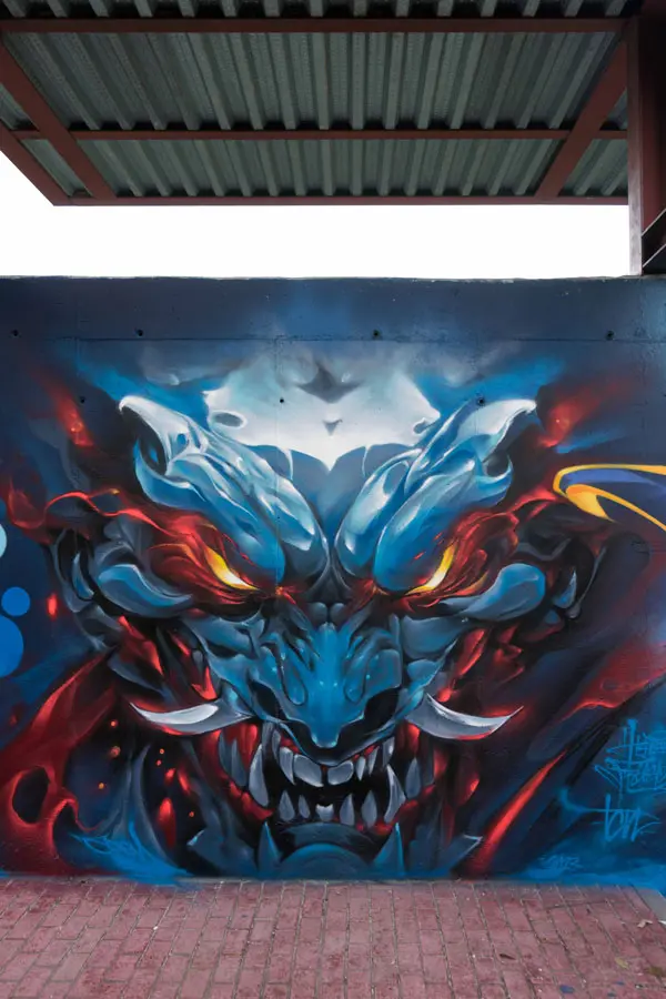 Graffiti de demonio japonés azul con ojos encendidos en Madrid