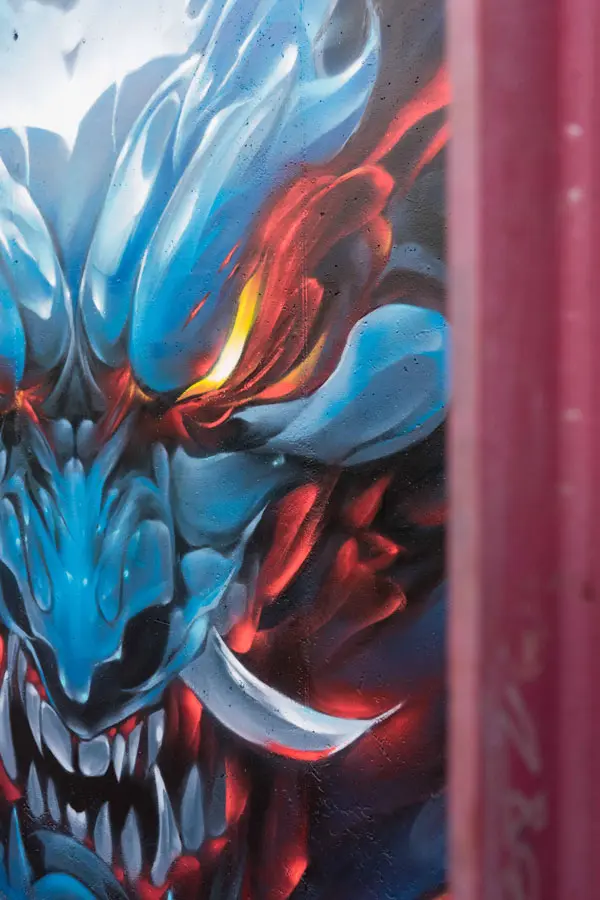 Graffiti de demonio japonés azul con ojos encendidos en Madrid