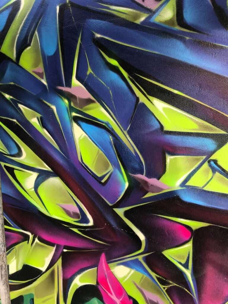 Mural de graffiti con letras en 3D y colores vivos en festival de Brasil