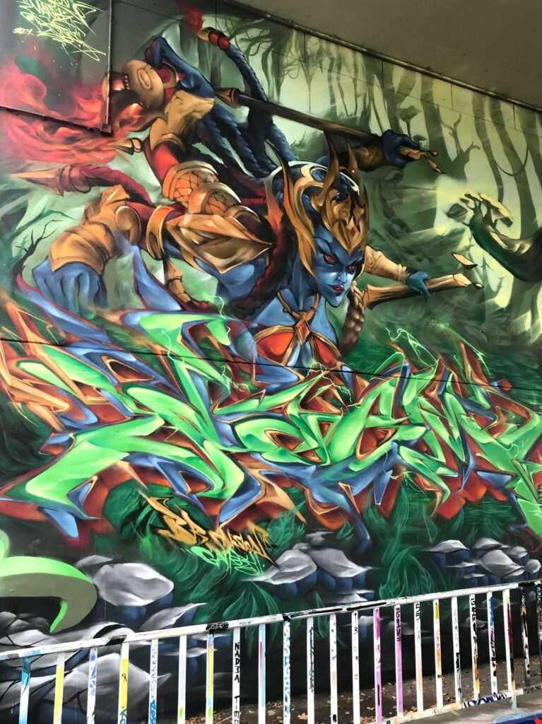 Graffiti de guerrera azul en un bosque con letras wildstyle. Festival Meeting Of Styles en Wiesbaden, Alemania