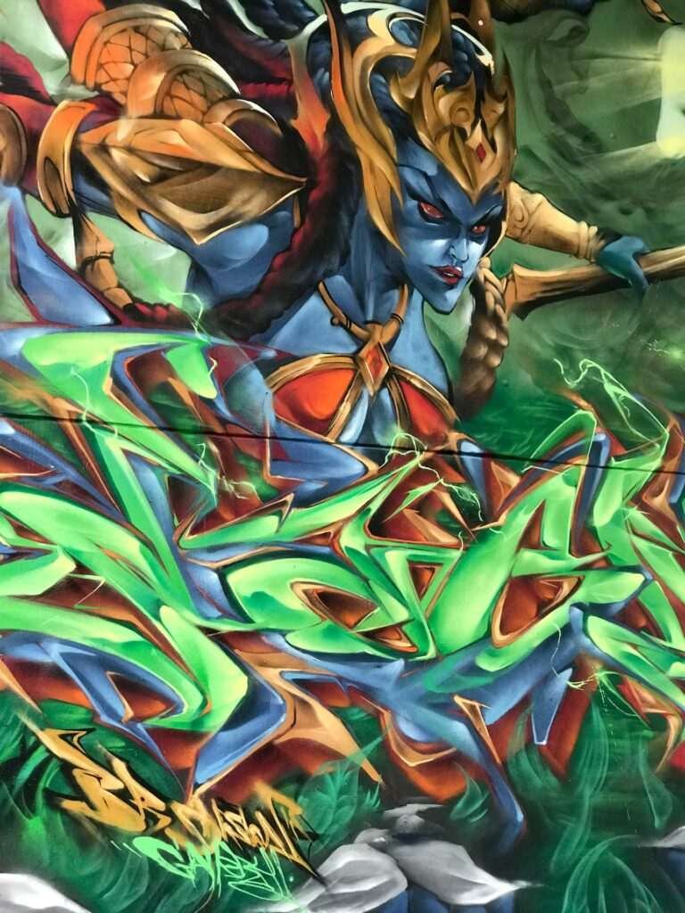 Graffiti de guerrera azul en un bosque con letras wildstyle. Festival Meeting Of Styles en Wiesbaden, Alemania