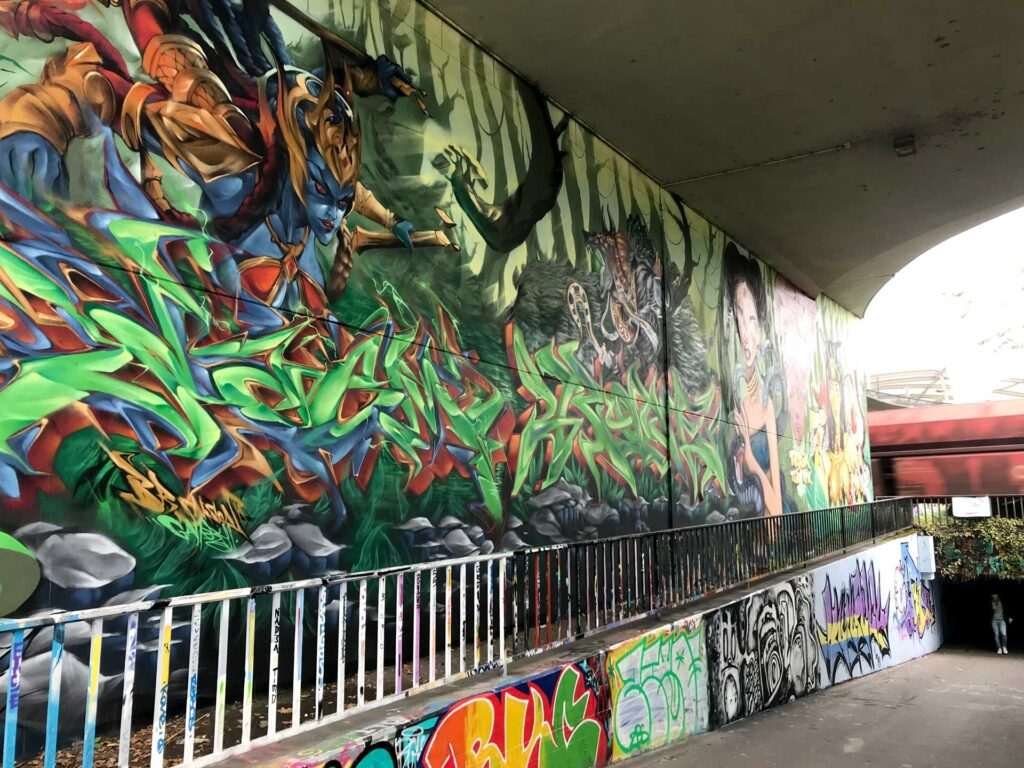 Graffiti de guerrera azul en un bosque con letras wildstyle. Festival Meeting Of Styles en Wiesbaden, Alemania