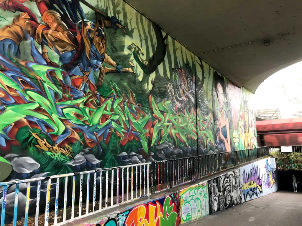 Graffiti de guerrera azul en un bosque con letras wildstyle. Festival Meeting Of Styles en Wiesbaden, Alemania