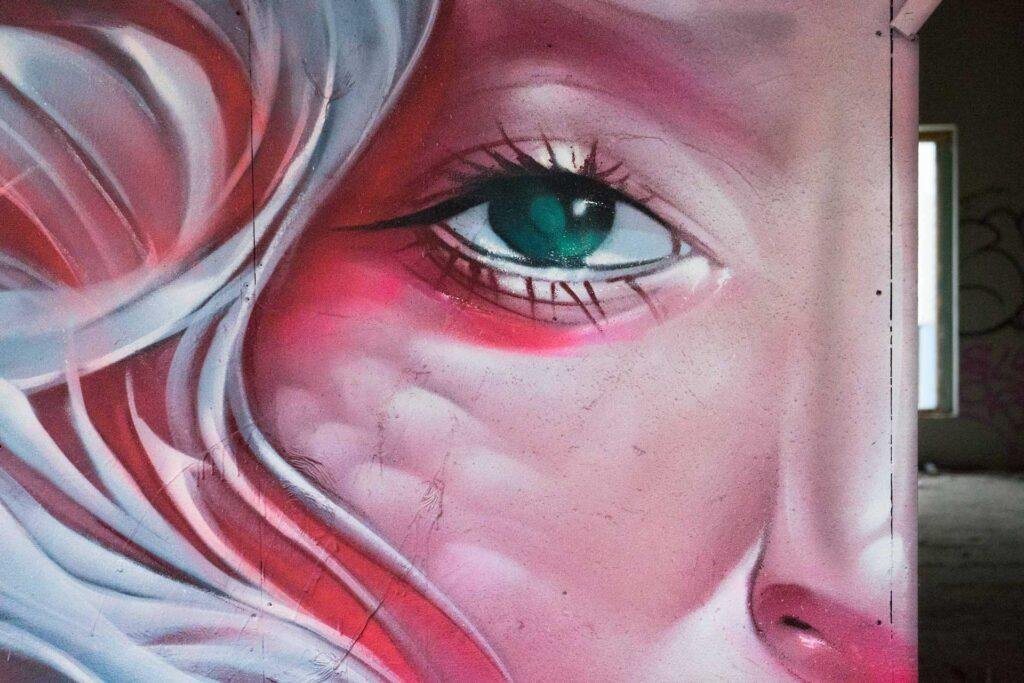 Mural retrato femenino hiperrealista en tonos rosados y blancos