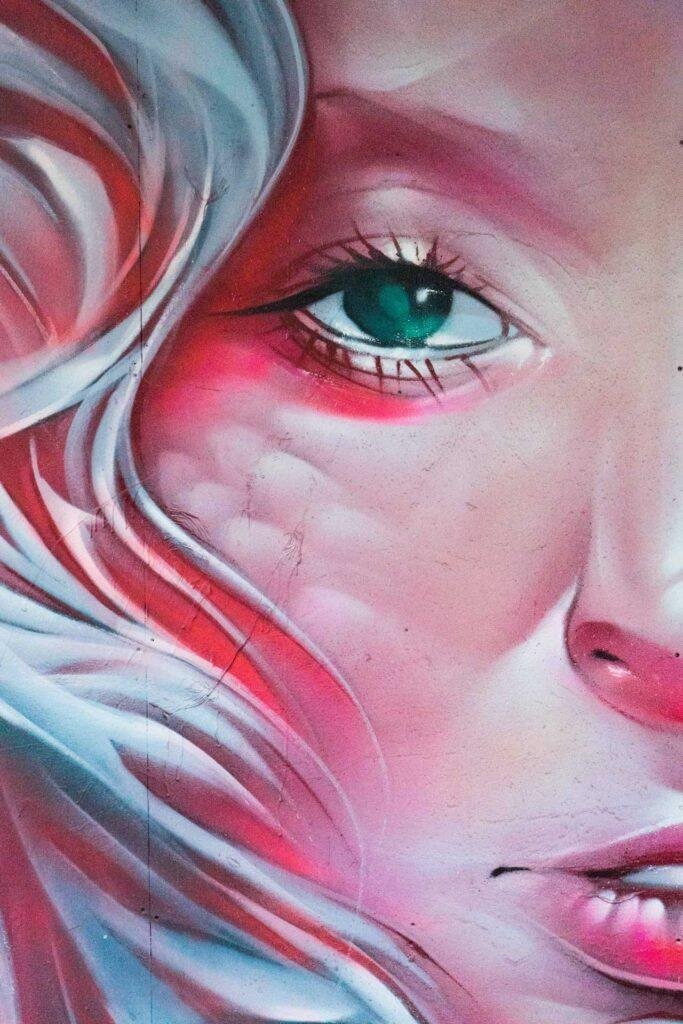 Mural retrato femenino hiperrealista en tonos rosados y blancos