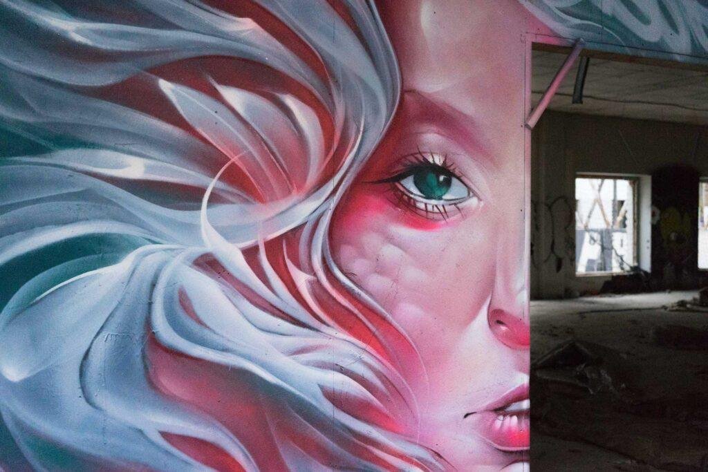 Mural retrato femenino hiperrealista en tonos rosados y blancos