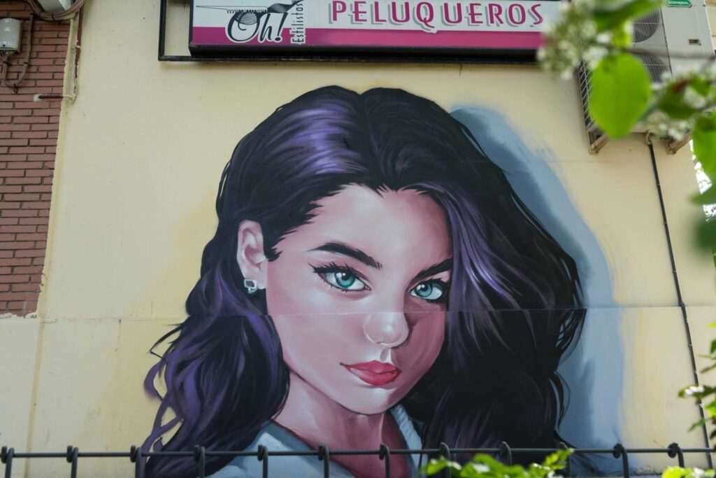 Graffiti de mujer en fachada de Oh Peluqueros en el Barrio del Pilar, Madrid