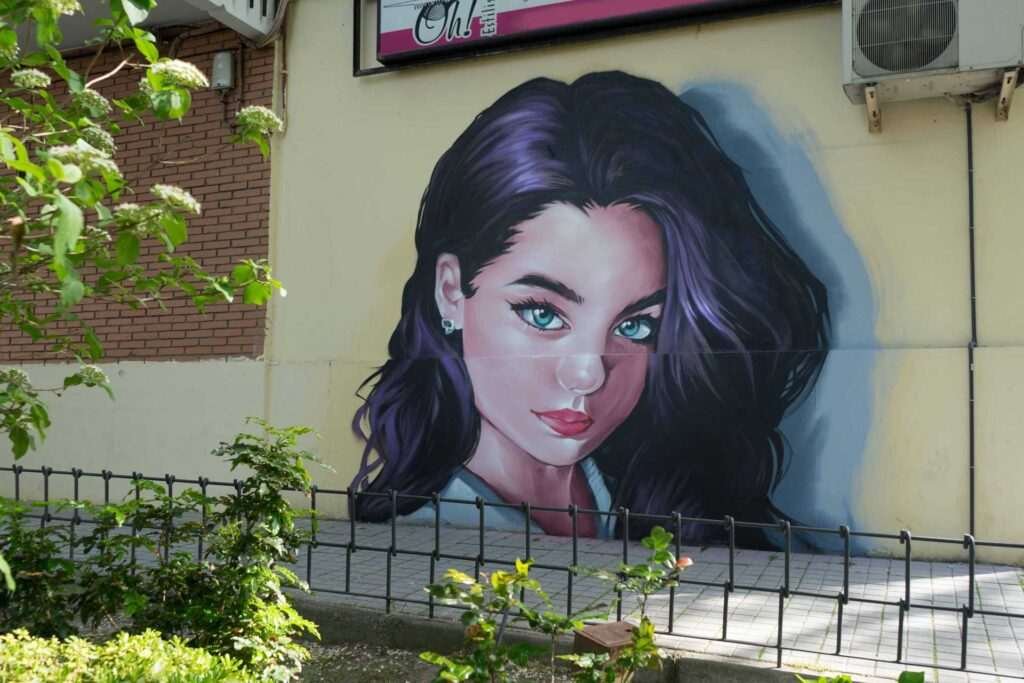 Graffiti de mujer en fachada de Oh Peluqueros en el Barrio del Pilar, Madrid