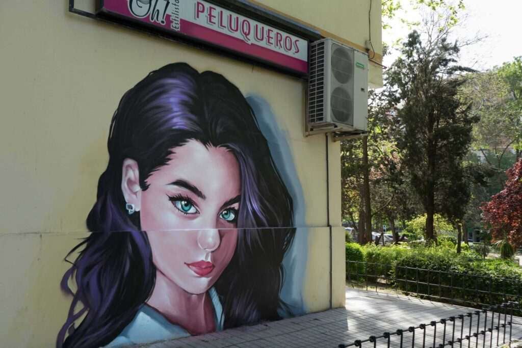 Graffiti de mujer en fachada de Oh Peluqueros en el Barrio del Pilar, Madrid