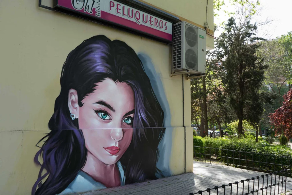 Graffiti de mujer en fachada de Oh Peluqueros en el Barrio del Pilar, Madrid
