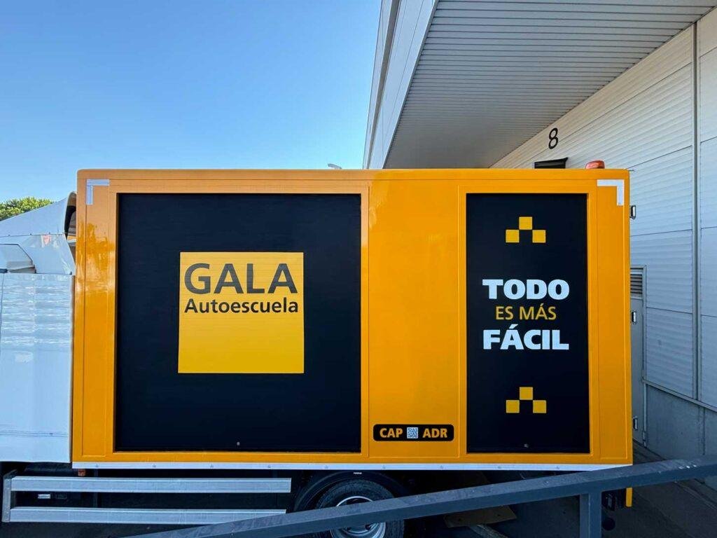 Camión amarillo y negro con rotulación de Autoescuela Gala y lema "Todo es más fácil"