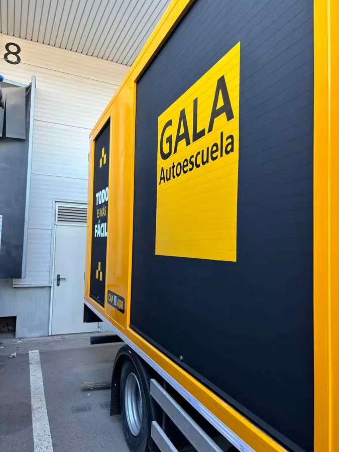 Camión amarillo y negro con rotulación de Autoescuela Gala y lema "Todo es más fácil"