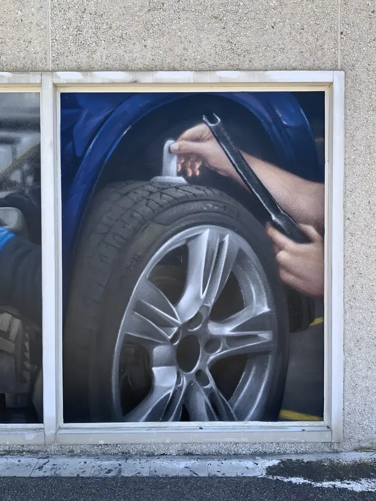 Graffiti profesional con imágenes de coches en taller Euromaster Tortosa