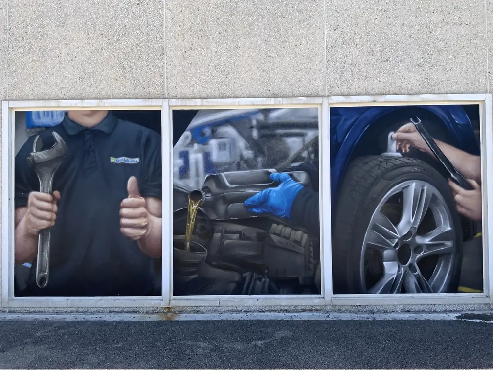 Graffiti profesional con imágenes de coches en taller Euromaster Tortosa