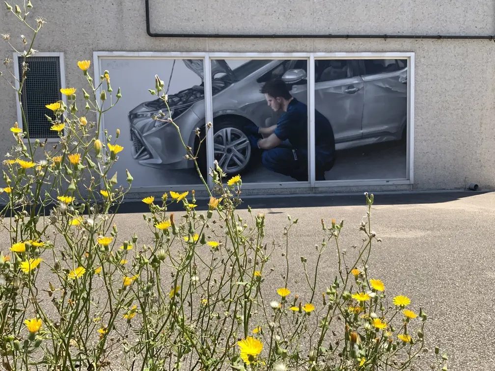 Graffiti profesional con imágenes de coches en taller Euromaster Tortosa
