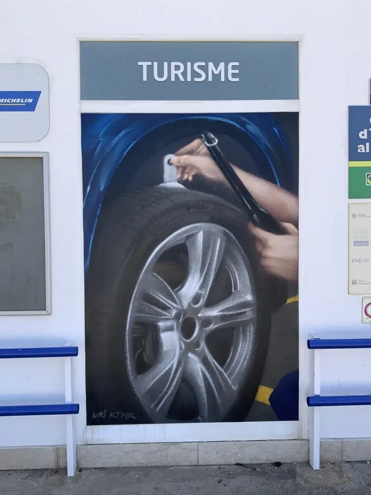Graffiti profesional con imágenes de coches en taller Euromaster Tortosa