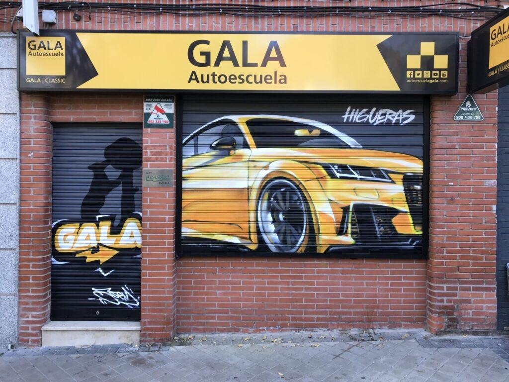 Fachada de GALA Autoescuela Higueras en Madrid decorada con graffiti de coche deportivo y Oso y Madroño
