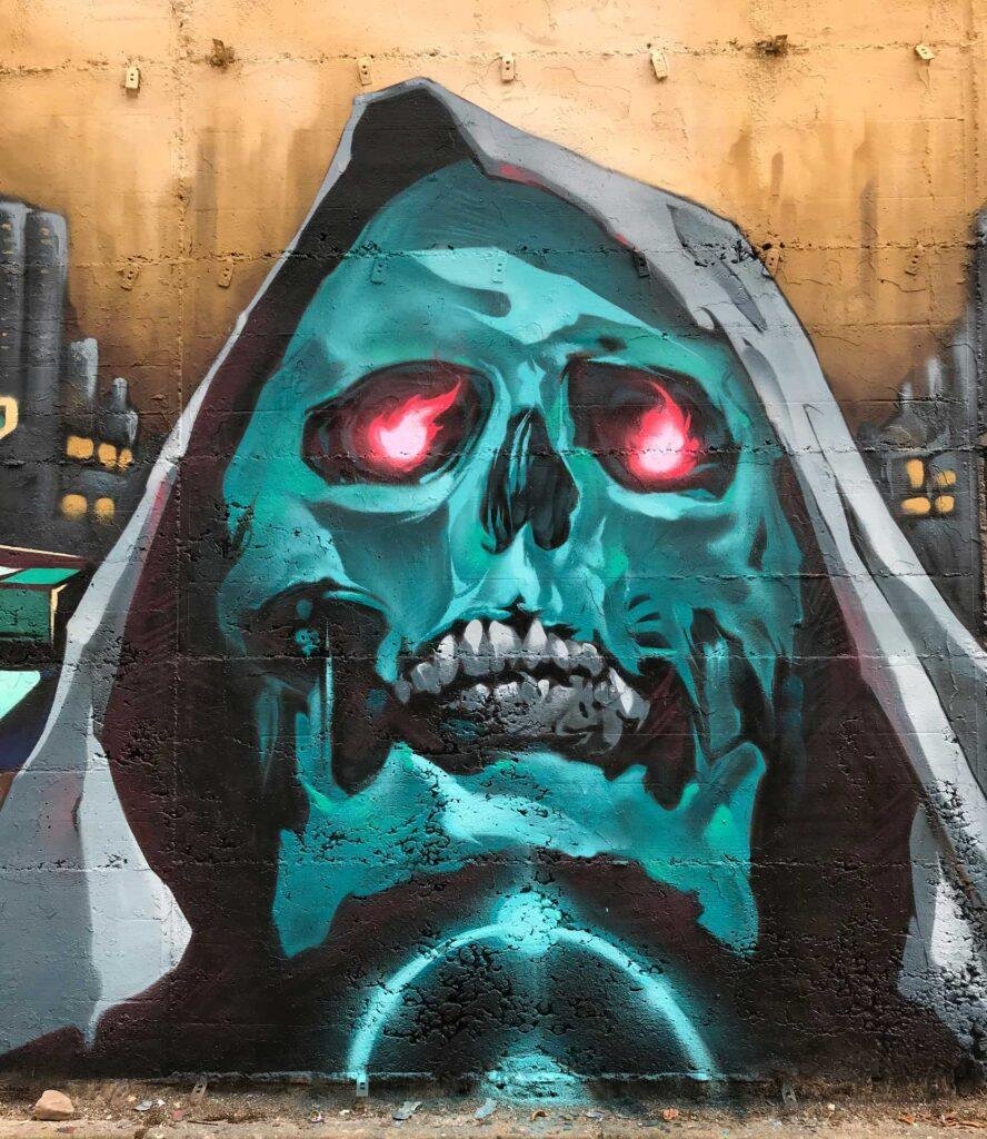 Graffiti de calavera azul con capucha y ojos rojos brillantes