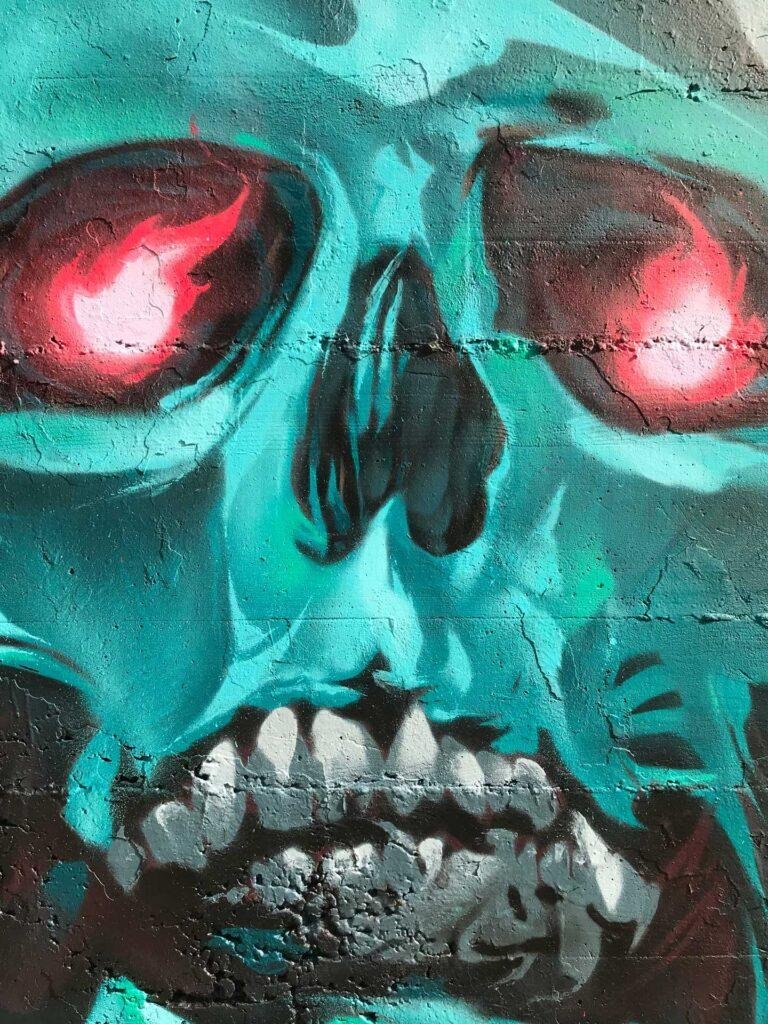 Graffiti de calavera azul con capucha y ojos rojos brillantes