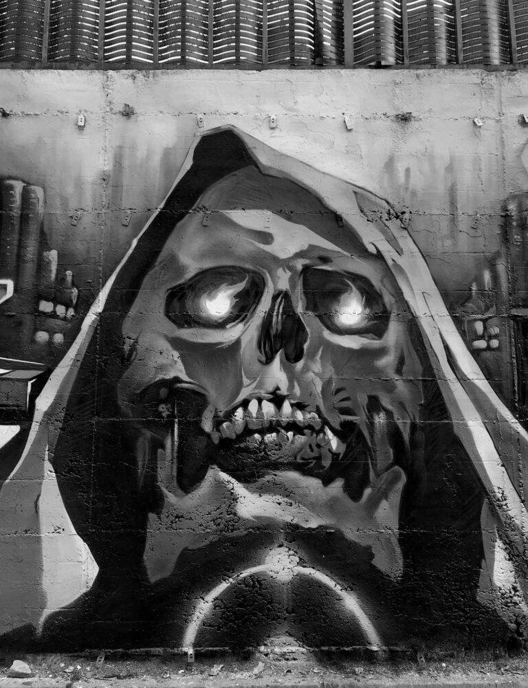 Graffiti de calavera azul con capucha y ojos rojos brillantes