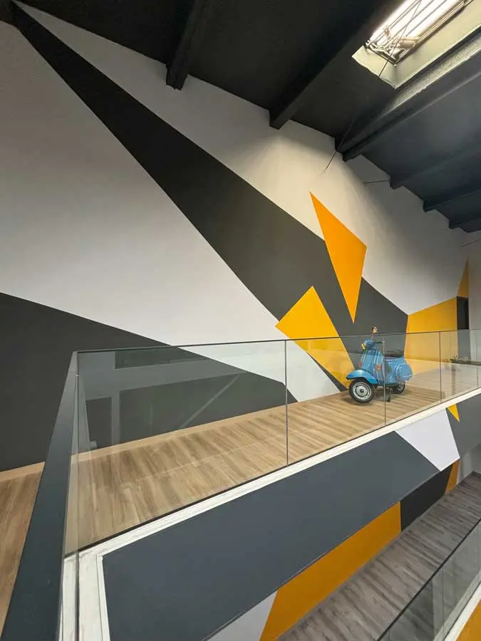Mural geométrico en sede Gala FP, arte decorativo en interior a tres niveles