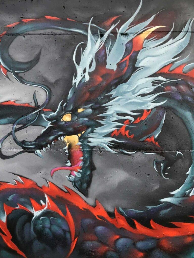 Mural urbano de dragón japonés en estilo mitológico con fuego