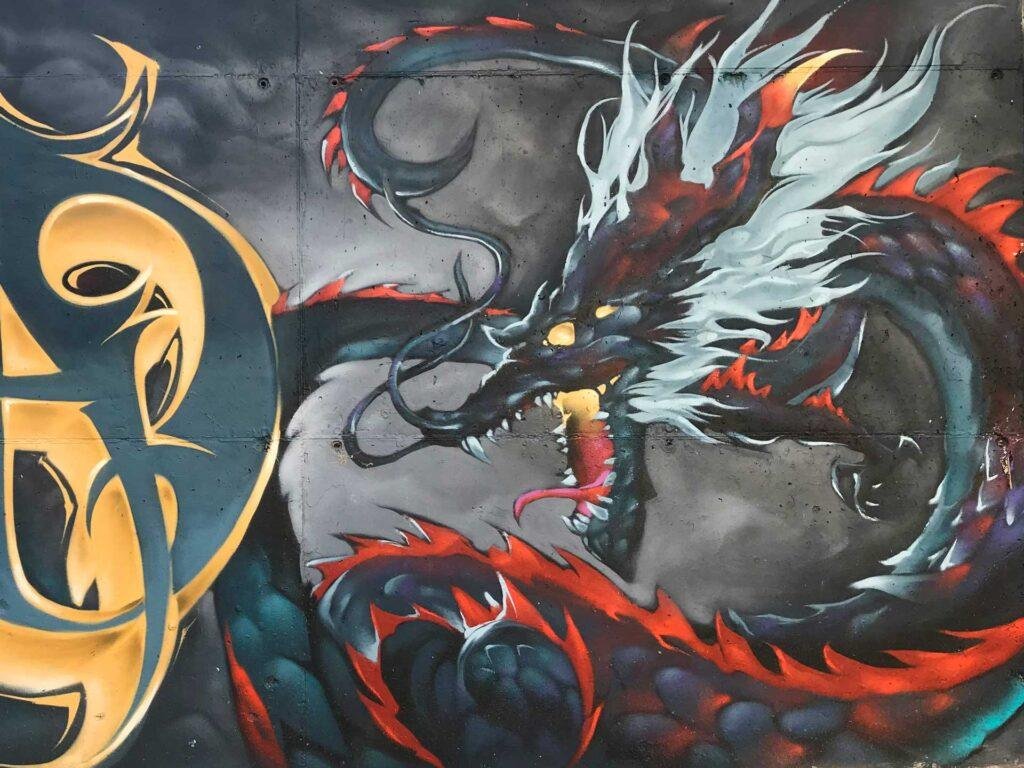 Mural urbano de dragón japonés en estilo mitológico con fuego