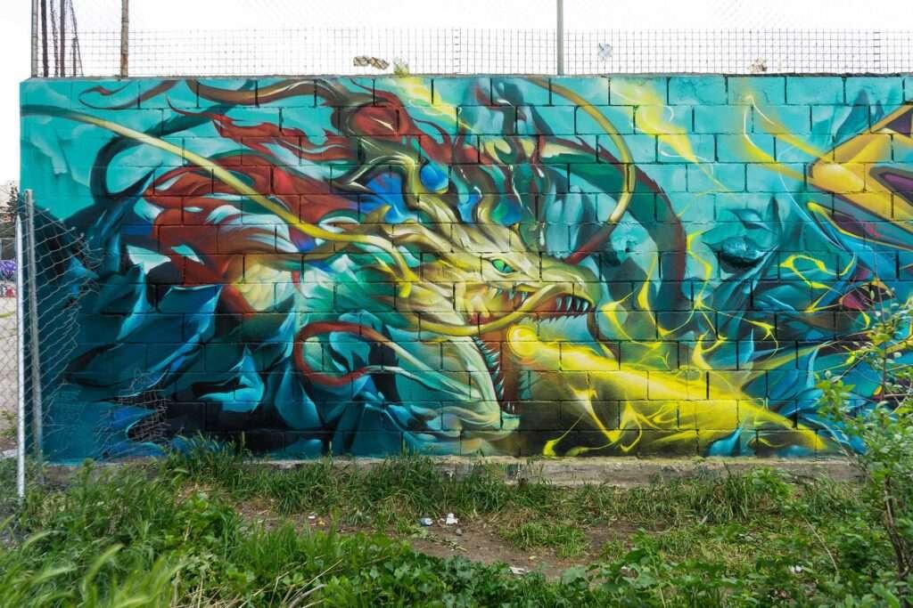 Graffiti de dragón lanzando fuego sobre fondo azul